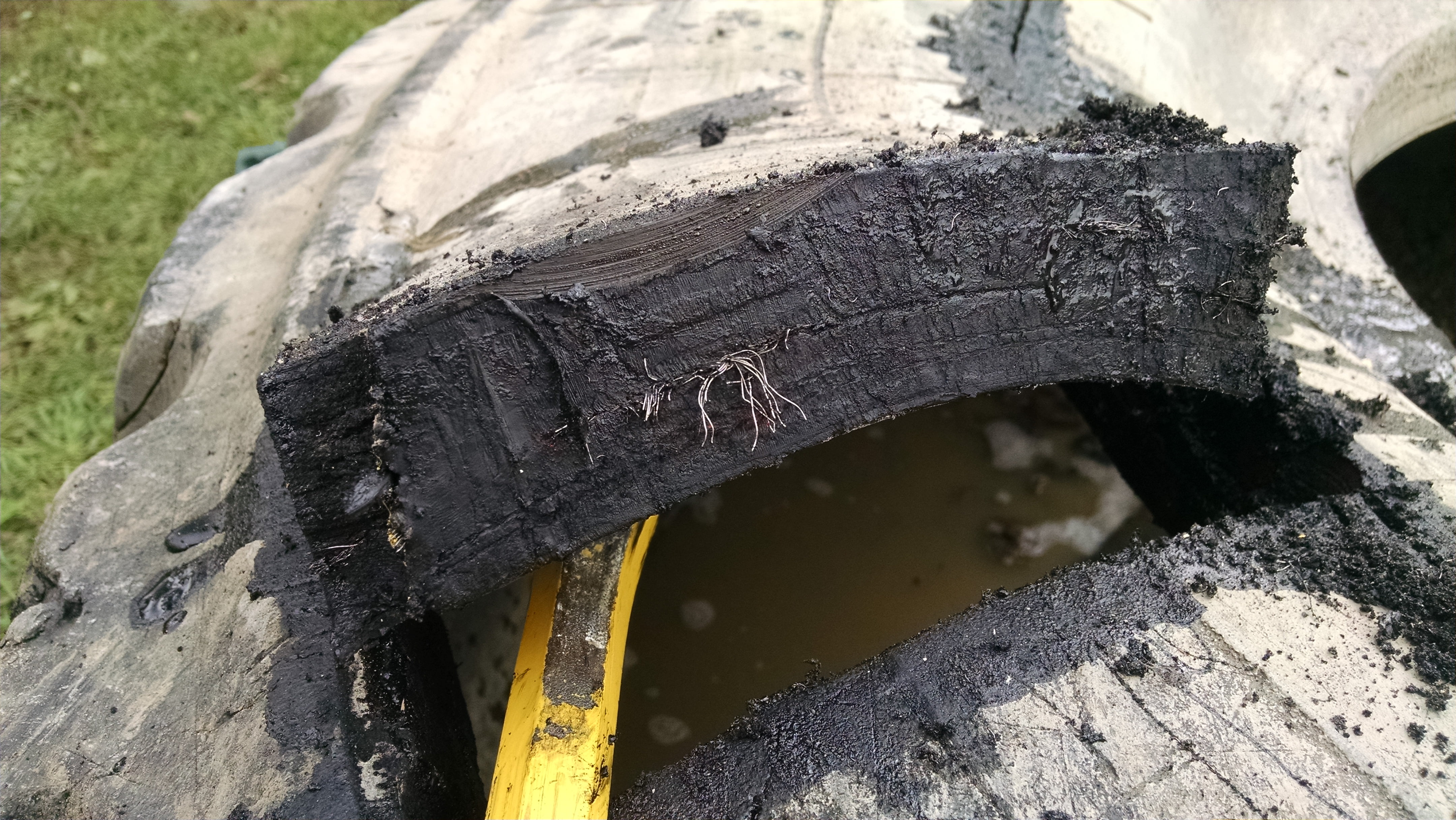 It helps to pry up on the sidewall while cutting.  This sidewall is about 1-1/2 inches thick with several sandwiched layers of rubber and steel.