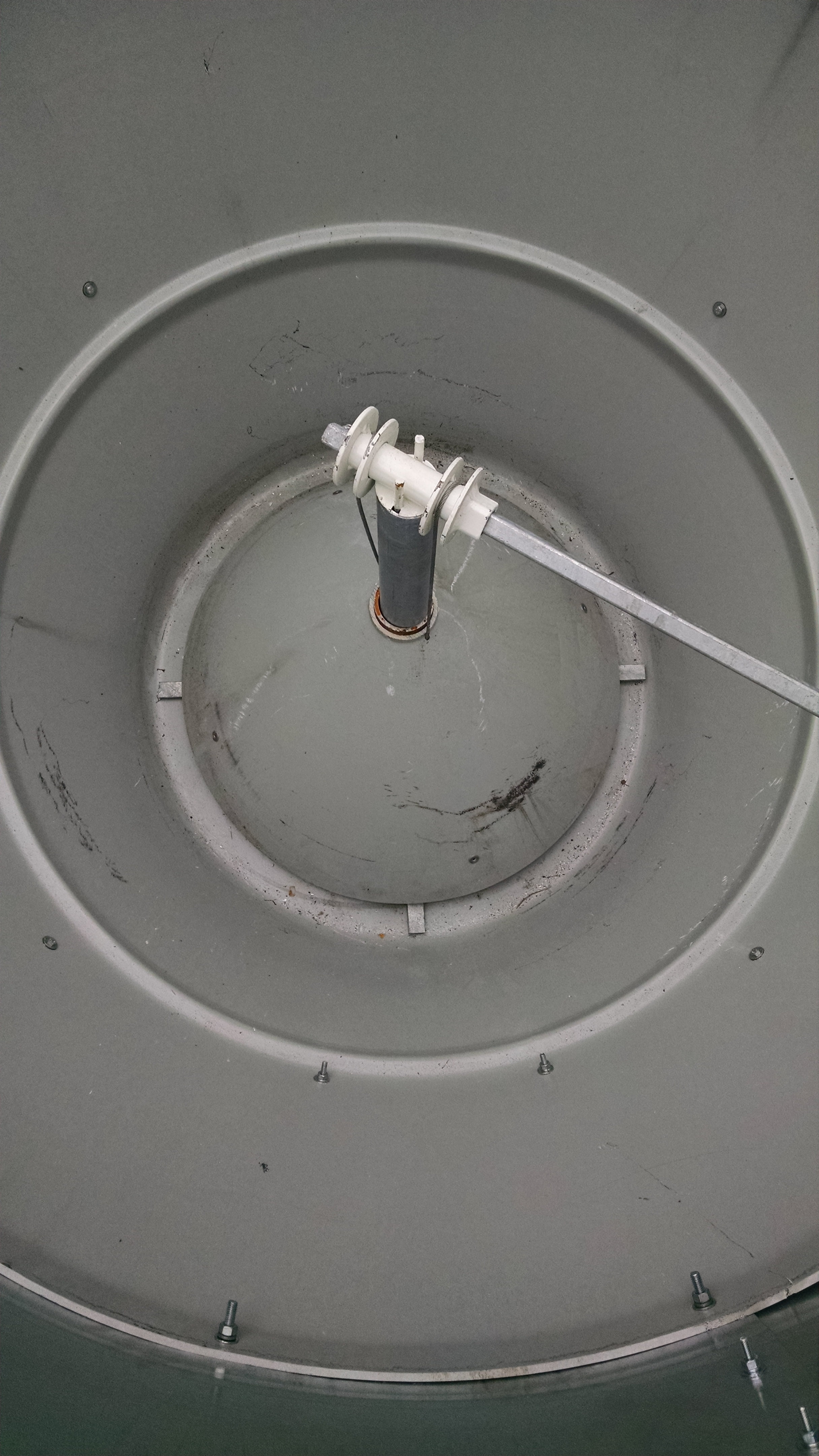 Looking down from the top.  The outer wall tapers in toward the bottom and an inner cone in the center directs feed to a spinning agitator just below.  The inner cone is raised by cables to adjust the gap to control the flow of feed.