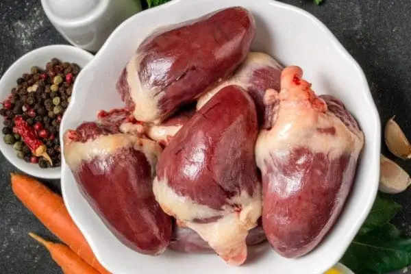 Pasture Raised, Certified Organic Turkey Hearts in a Bowl with Carrots, Garlic, and Spices.