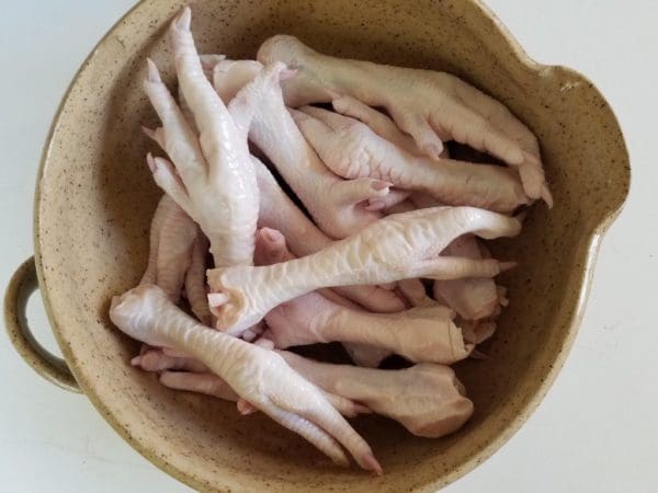 Pasture raised and Certified Organic chicken feet from Wrong Direction Farm in a ceramic bowl.