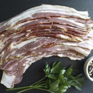 Pasture raised bacon laid out on a stone cutting board