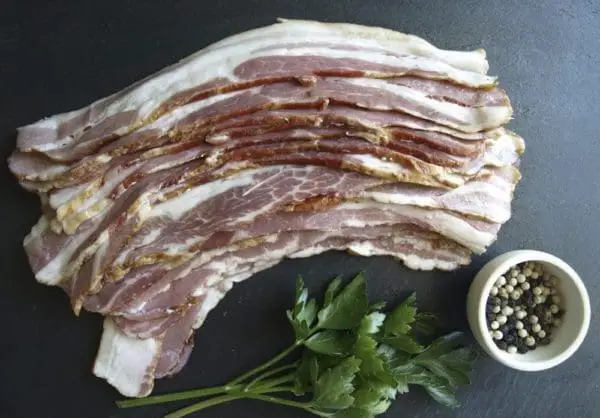 Pasture raised bacon laid out on a stone cutting board