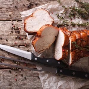 Roasted and Tied Pasture Raised, Certified Organic Turkey Breast on wood cutting board.