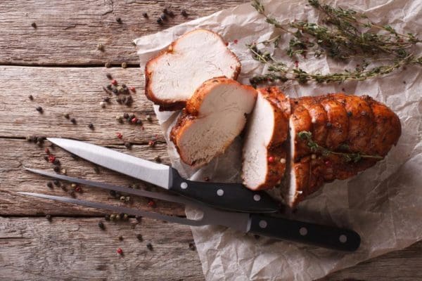 Roasted and Tied Pasture Raised, Certified Organic Turkey Breast on wood cutting board.