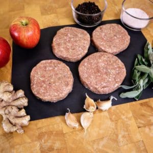 Pasture raised turkey breakfast sausage patties from Wrong Direction Farm on a butcher block cutting board along with all ingredients.