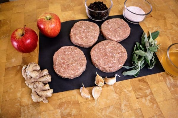 Pasture raised turkey breakfast sausage patties from Wrong Direction Farm on a butcher block cutting board along with all ingredients.