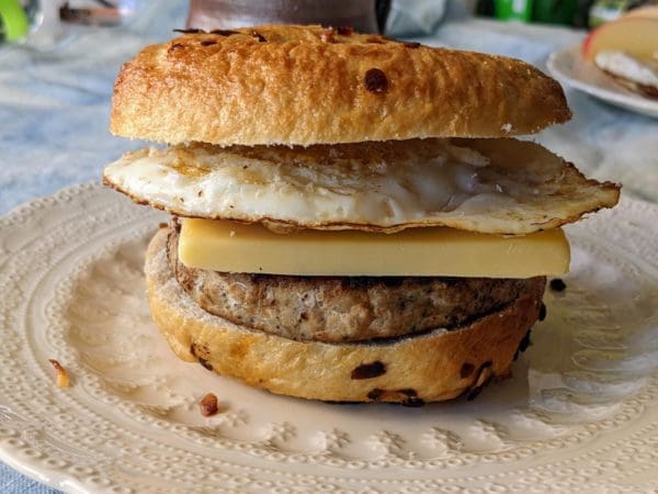 Pasture raised turkey breakfast sausage patty with eggs and cheese on a bagel on a plate in the kitchen at Wrong Direction Farm