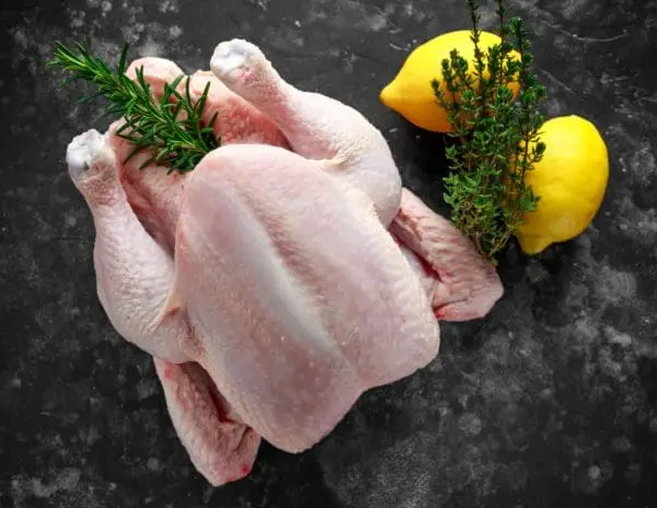 Raw pasture raised chicken with rosemary and lemon.