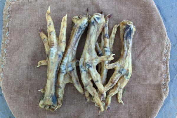 Dried pasture raised and certified organic chicken feet on a cloth backdrop