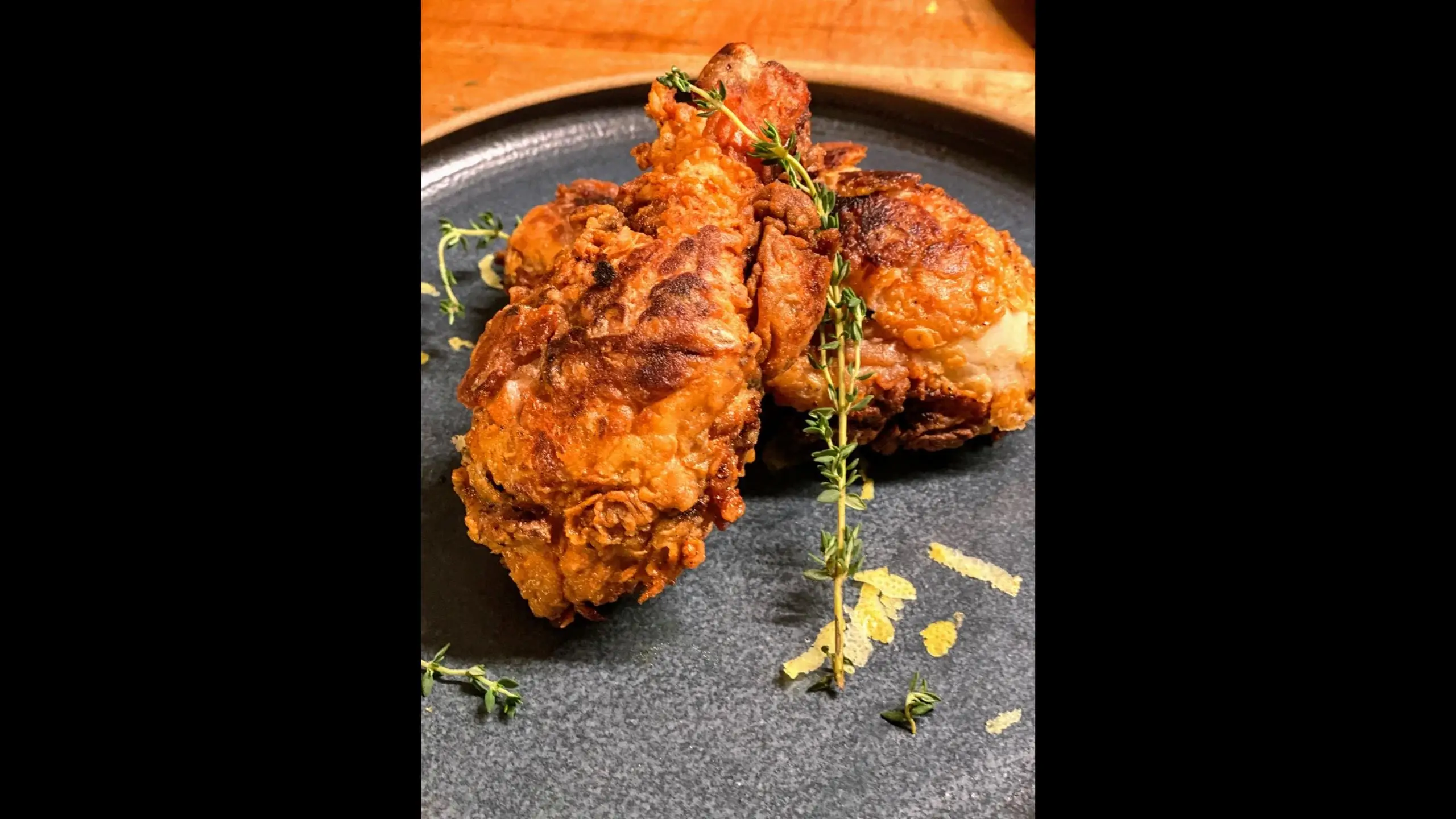 Fried pasture raised and certified organic chicken drumsticks from Wrong Direction Farm served on ceramic plate.