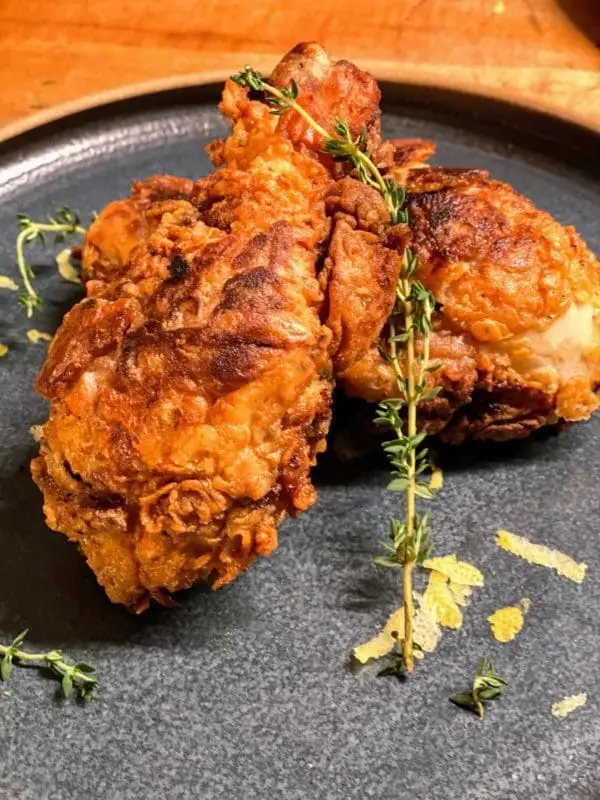 Fried pasture raised and certified organic chicken drumsticks from Wrong Direction Farm served on ceramic plate.