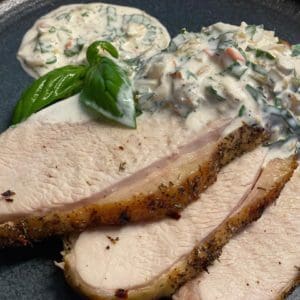Roasted and sliced pasture raised turkey breasts from Wrong Direction Farm. Served on a plate with kimchi and herb sauce.