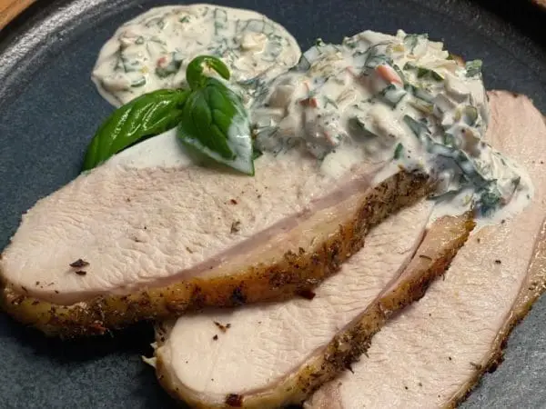 Roasted and sliced pasture raised turkey breasts from Wrong Direction Farm. Served on a plate with kimchi and herb sauce.