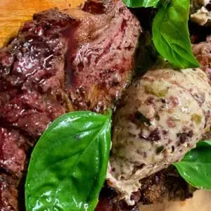 Grass fed ribeye steak served with basil and tapenade butter.